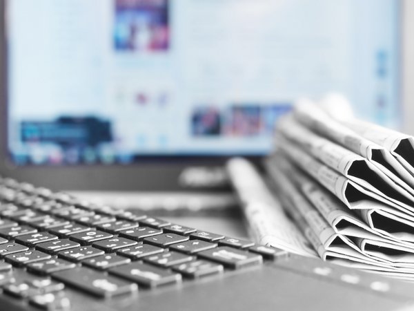 Bild einer Tastatur, Zeitung und eines Monitors