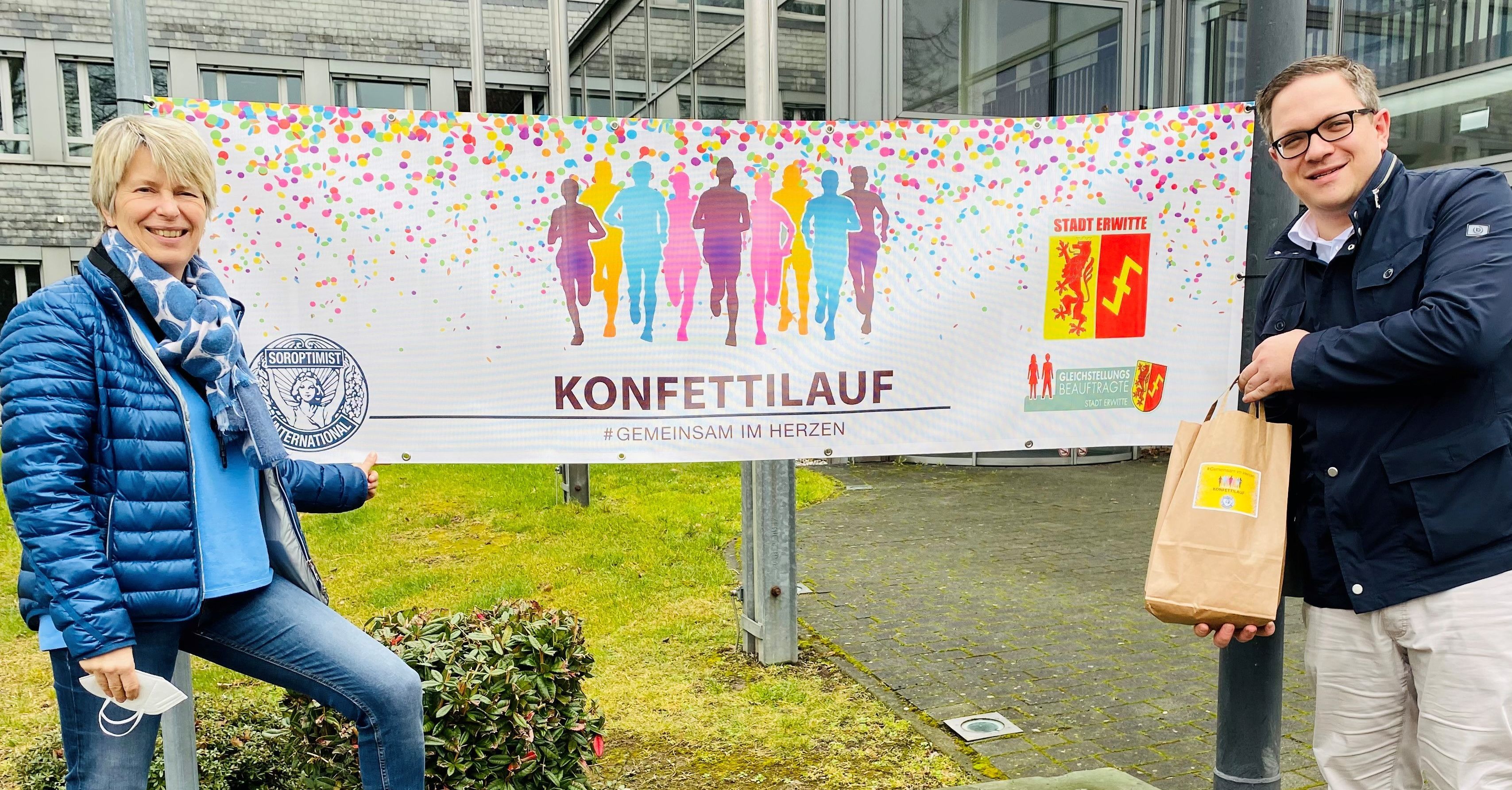 Banner des Konfettilaufs (v. l. Gleichstellungsbeauftragte Birgit Wortmann und Bürgermeister Hendrik Henneböhl)